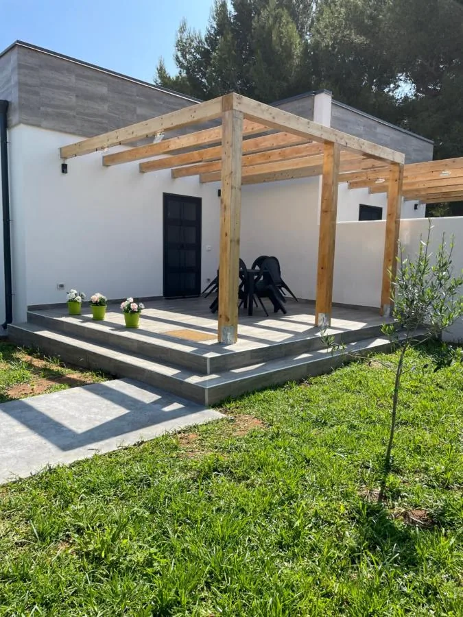 Pergolato in legno sopra la veranda, con il prato del giardino