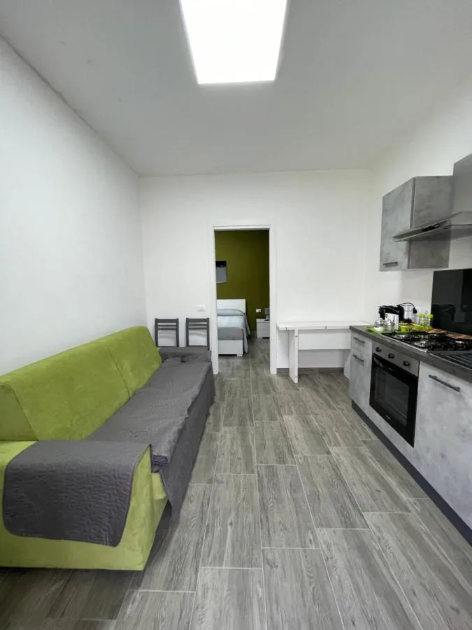 Soggiorno di Gordon Lime con divano verde e cucina