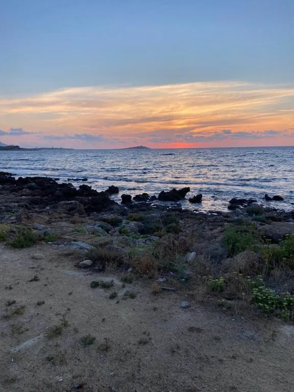 Tramonto sul mare con un'isola all'orizzonte